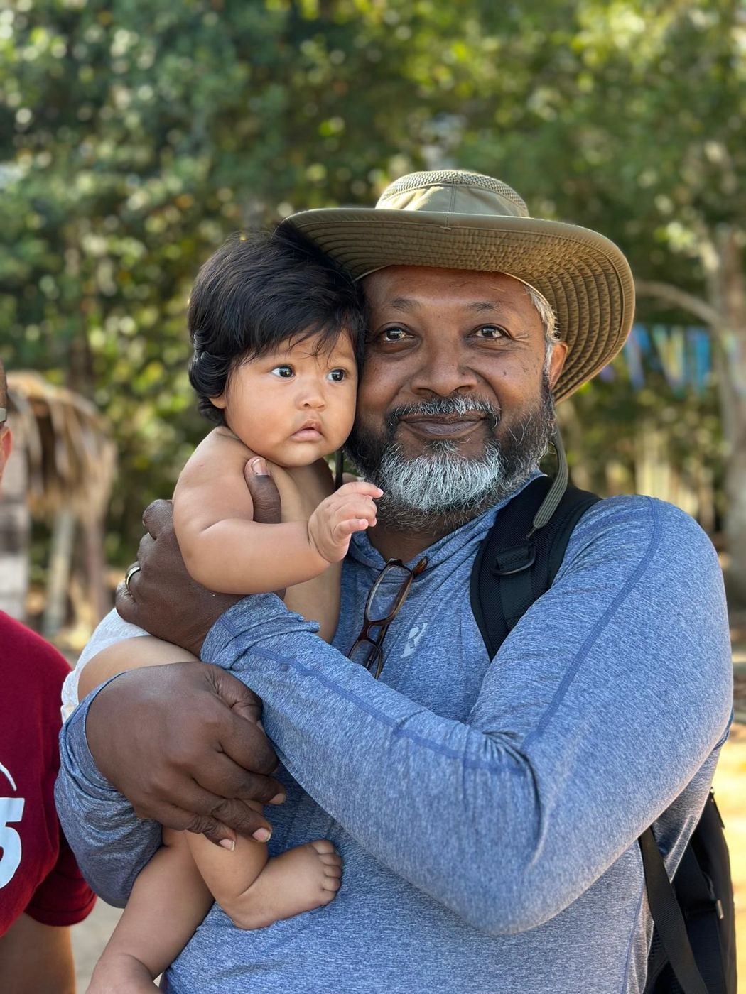 Kris Ramsingh, founder, holding a baby on a trip to Brazil