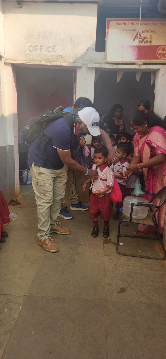 Handing out supplies to children at a doorway in India