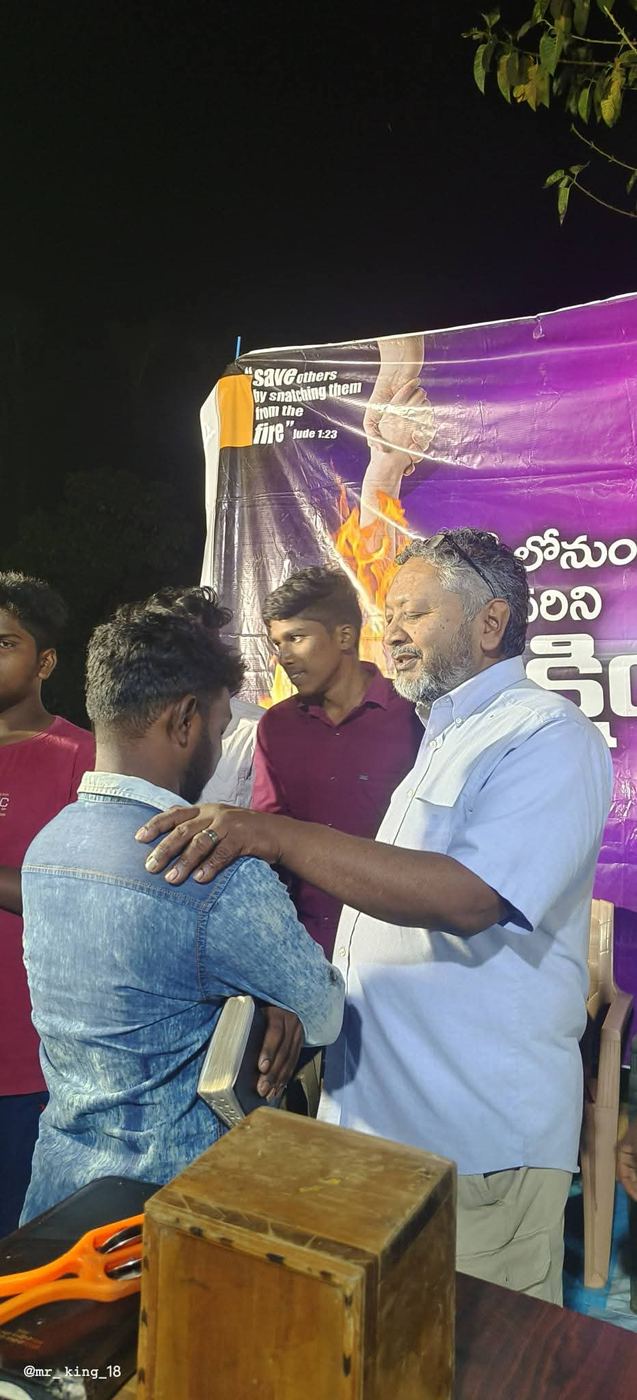 Praying with a man at an evening gathering in India