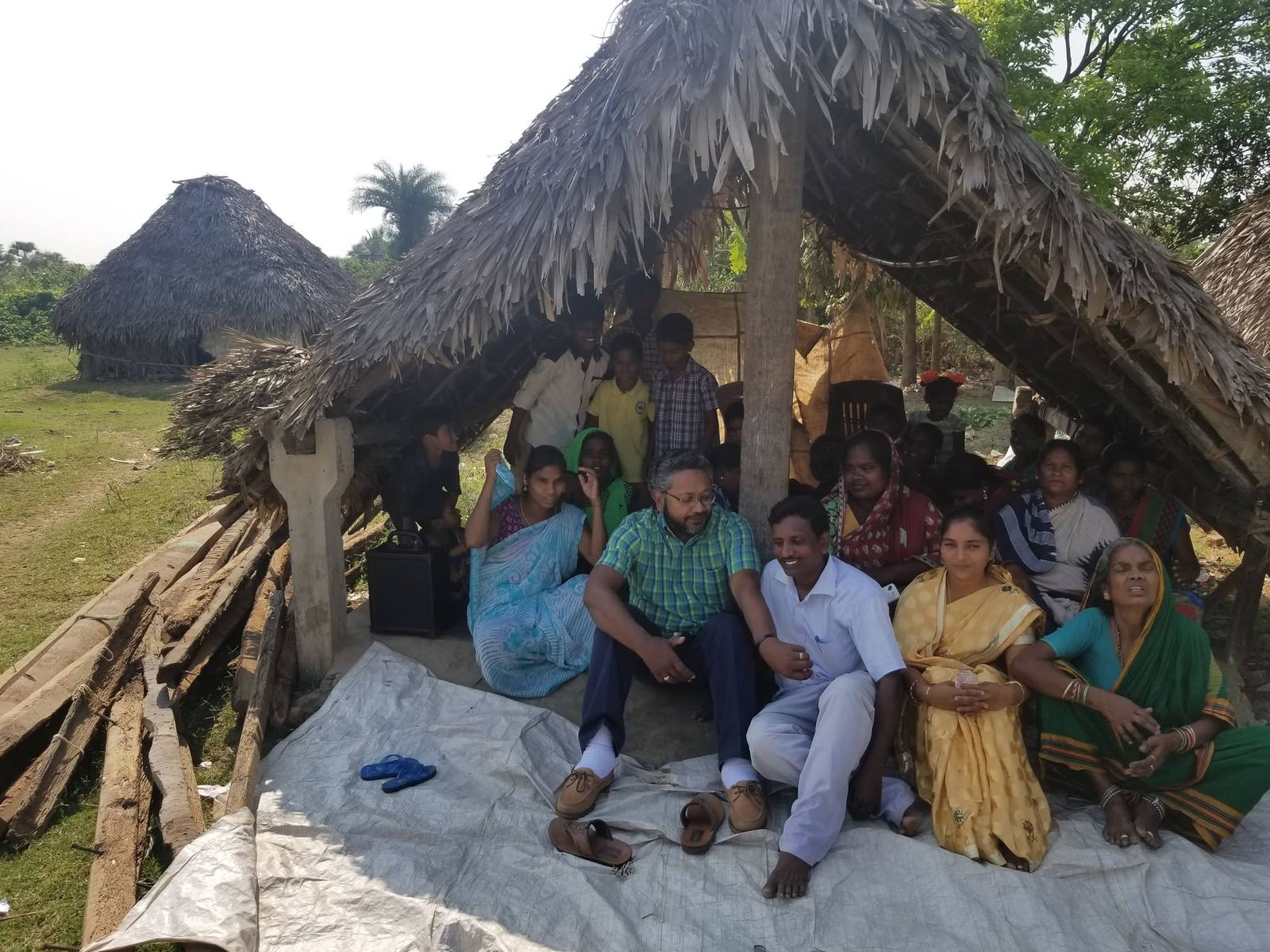 Village outreach under a thatched shelter in India