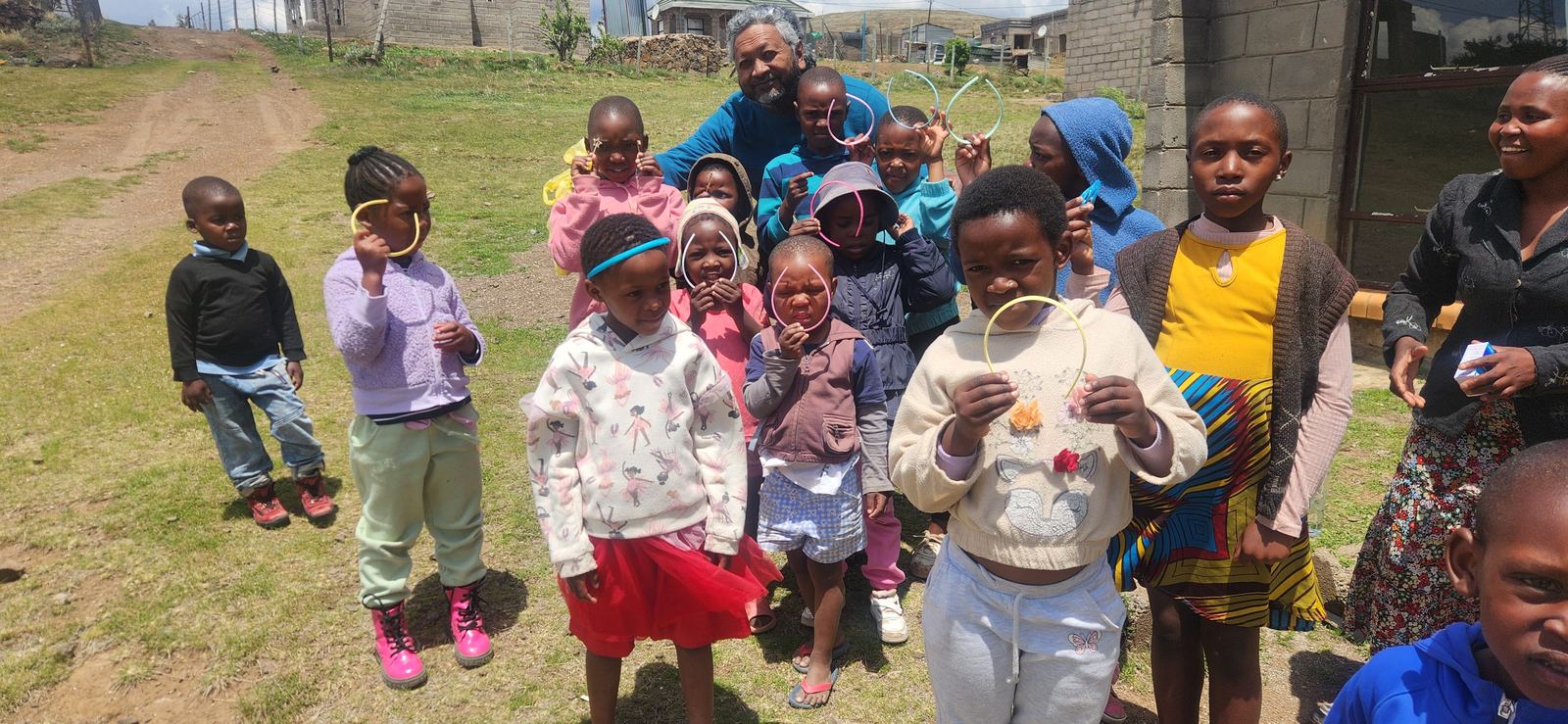 Smiling children holding crafts in Lesotho