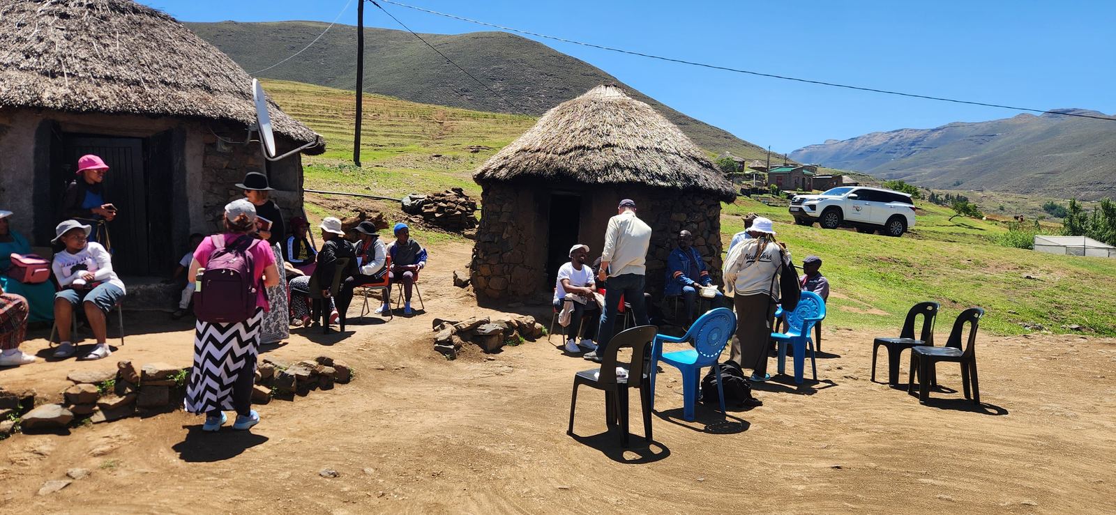 People gathered outside round thatched houses in Lesotho