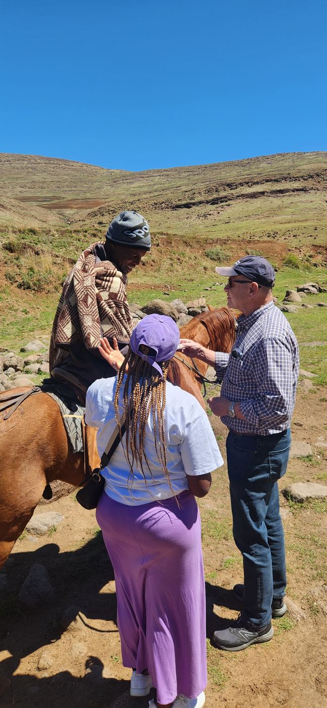 Team members with a villager on horseback in Lesotho