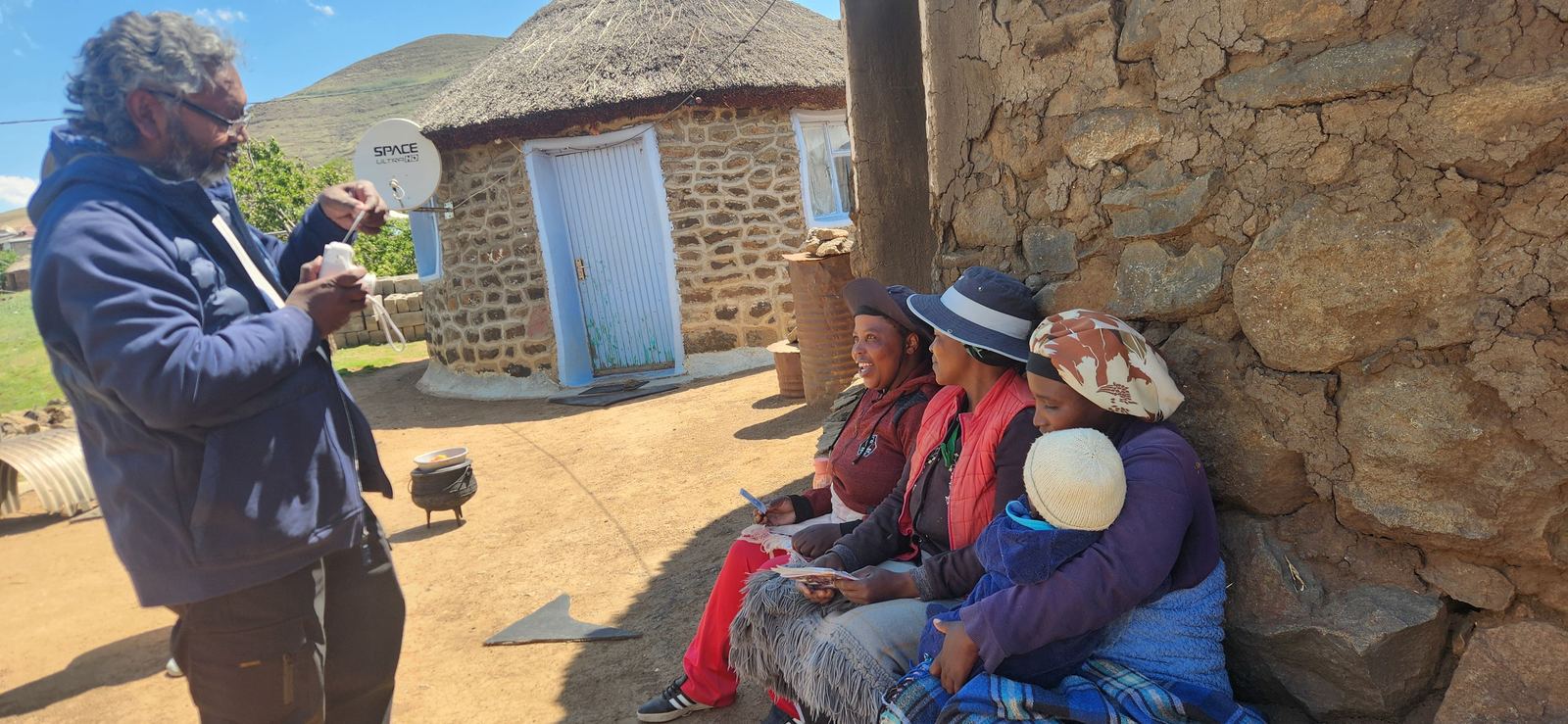 Visiting with women outside a stone house in Lesotho